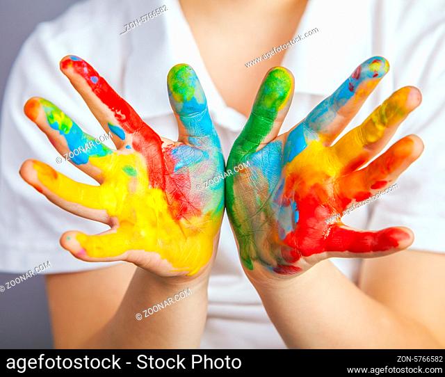 little girl and boy hands painted in colorful paints