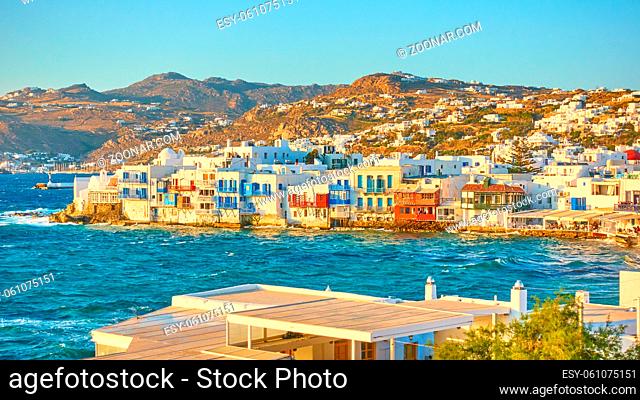 Panoramic view of Mykonos Island with famous houses by the water at sundown, Greece. Picturesque greek scenery