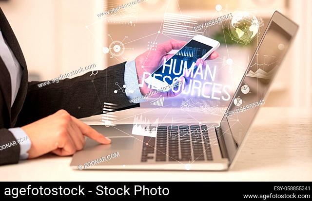 Side view of a business person working on laptop with HUMAN RESOURCES inscription, modern business concept