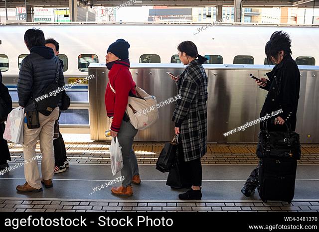 Nagoya, Japan, Asia - Rail passengers wait for the Shinkansen Bullet train on a station platform at the central station