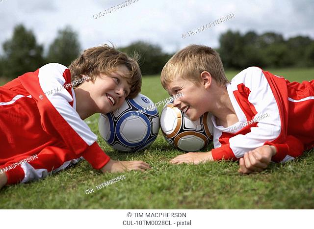 Two boys laughing with heads on balls