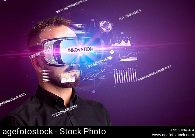 Businessman looking through Virtual Reality glasses with INNOVATION inscription, new business concept