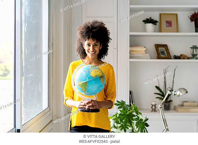 Beautiful woman holding globe, planning vacations