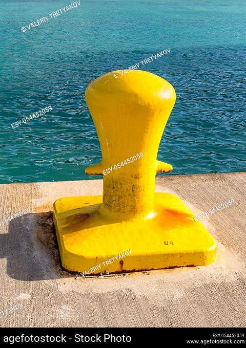 Maritime yellow mooring iron bollard on the dock for big ship in Road Town, Tortola, British Virgin Islands