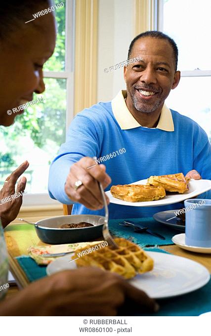 Close-up of a senior man and a senior woman having breakfast