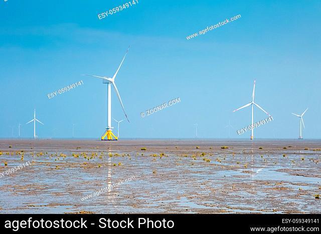 wind farm on tidal flat wetland with haze weather, clean energy background
