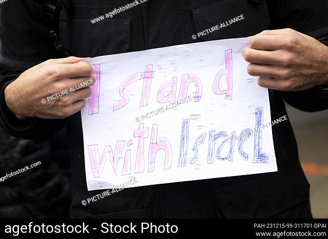 15 December 2023, Berlin: A participant in a Fridays for Israel demonstration stands in front of the entrance to the cafeteria of Freie Universität Berlin...