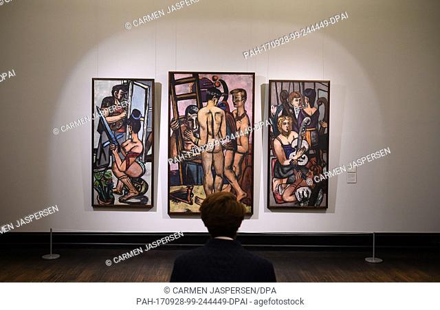 A woman looks at the paintings 'Argonauten. Triptychon' from 1949/50 by Max Beckmann (1884-1950) at the exhibition 'Max Beckmann. Welttheater' (lit