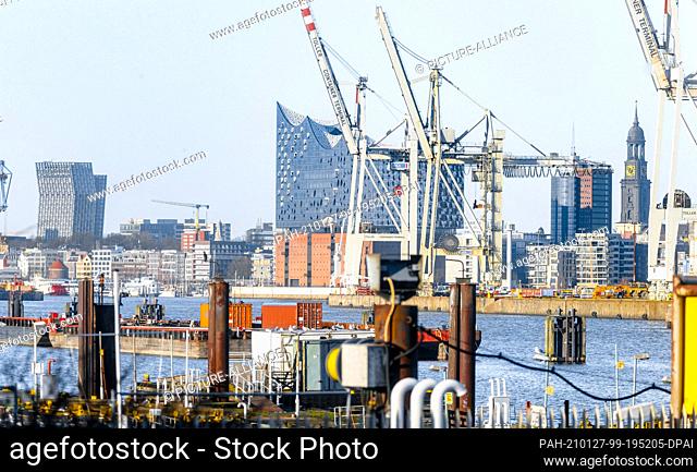 25 December 2020, Hamburg: The dancing towers of the Reeperbahn, the Elbphilharmonie behind container cranes of the Hansa harbour