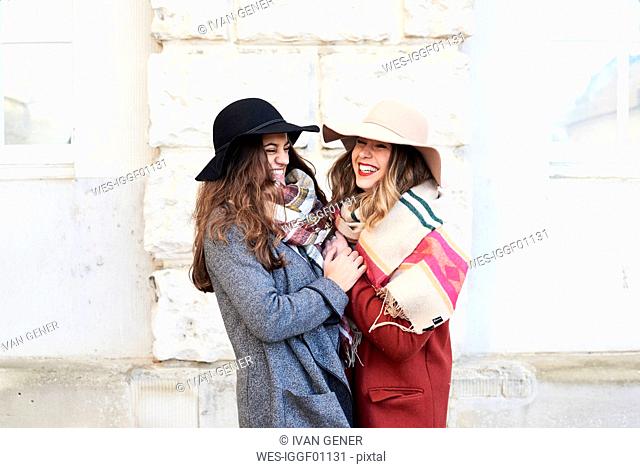 Two happy playful women wearing floppy hats