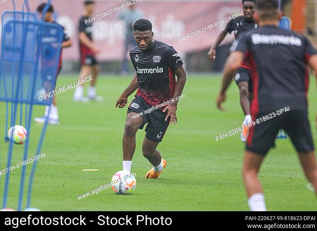 27 June 2022, North Rhine-Westphalia, Leverkusen: Soccer: Bundesliga, Training kick-off Bayer Leverkusen, Leverkusen's Timothy Fosu-Mensah has the ball at his...