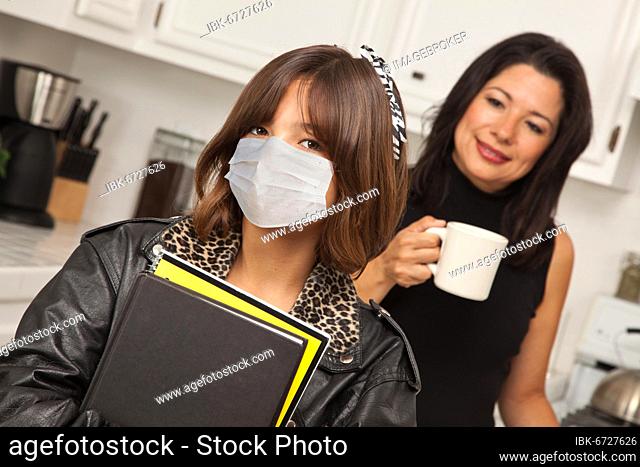 Young hispanic girl student with mother at home getting ready for school wearing medical face mask