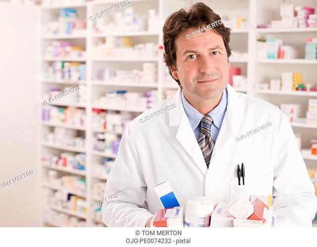 Pharmacist in drug store holding medications