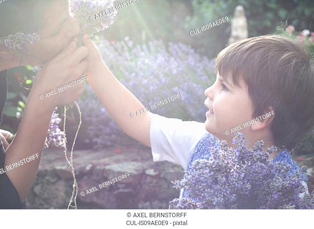 Portrait of mother and toddler son smelling lavender