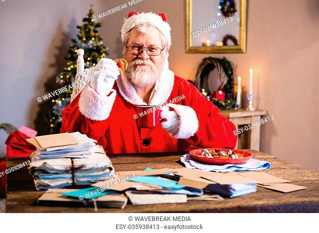 Santa Claus having a cookie with coffee