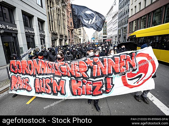 20 March 2021, Berlin: Various initiatives and left-wing groups demonstrate against a demo of right-wing extremists and so-called ""Reichsbürger"" with a banner...