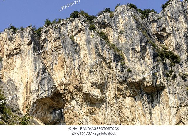 landscape with overhanging rocks , shot in bright fall light near Arco, Trento, Italy