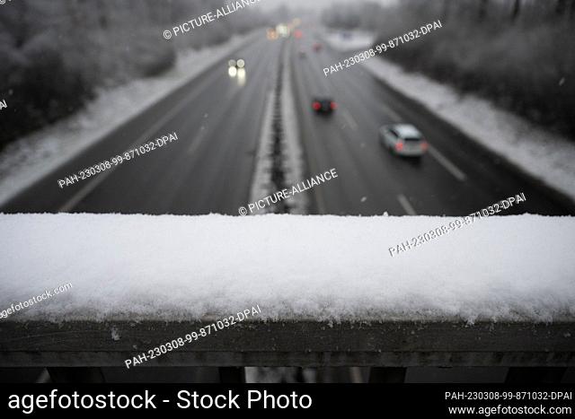 08 March 2023, Hesse, Gießen: Snow lies on a railing above the A485. An official warning of snowfall by the German Weather Service is in effect in the district...