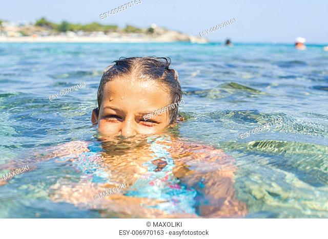 Young girl playing in the wave with spray