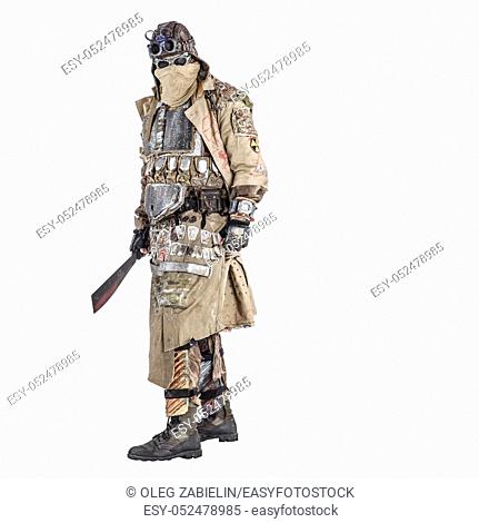 Scary post apocalyptic survivor in handmade armored clothes, armed with machete, dangerous creature with face hidden behind mask and glasses, in rags