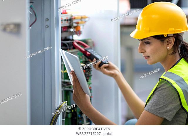 Female technician working on a box with circuit boards
