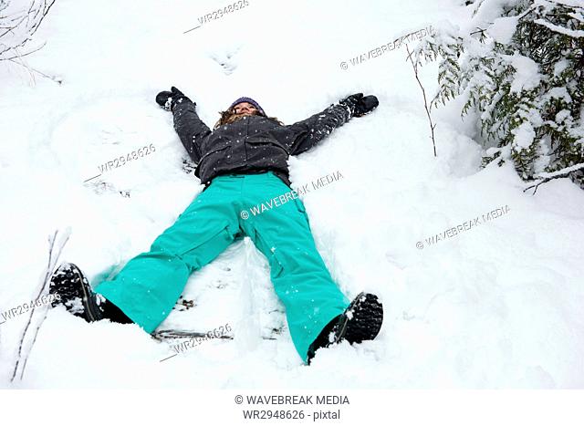 Woman doing snow angel on beautiful snowy day