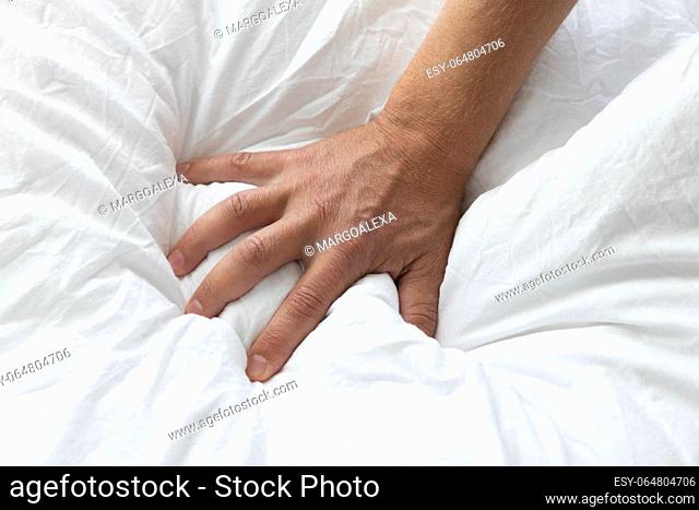 Man's hand squeezing a blanket, vintage white, soft focus. High quality photo