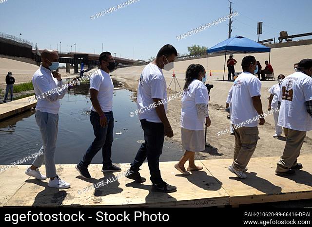 19 June 2021, Mexico, Ciudad Juarez: People with mouth-to-nose coverings line up during the #HugsNotWalls action by the NGO Border Network for Human Rights:...