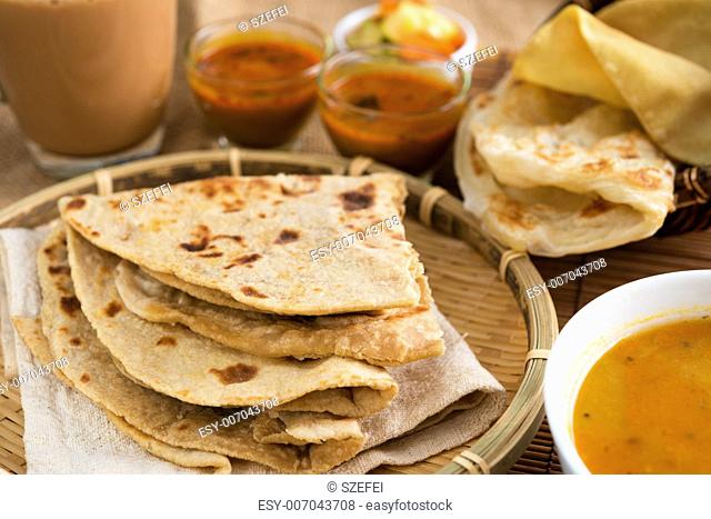 Indian food, Chapati flatbread, roti canai, dal, curry, teh tarik or pulled tea, acar. Famous indian cuisine