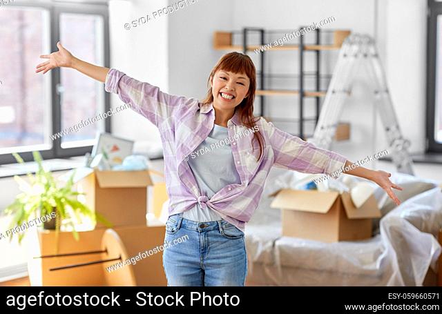happy asian woman with stuff moving to new home