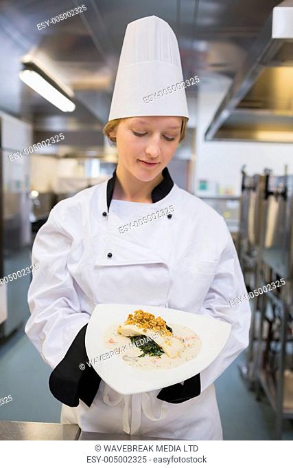 Female chef presenting her dish in the kitchen