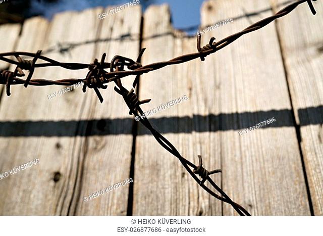 barbed wire on a wooden fence