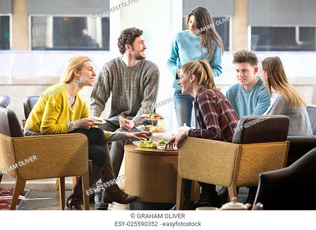 Group of friends having afternoon tea together in a cafe
