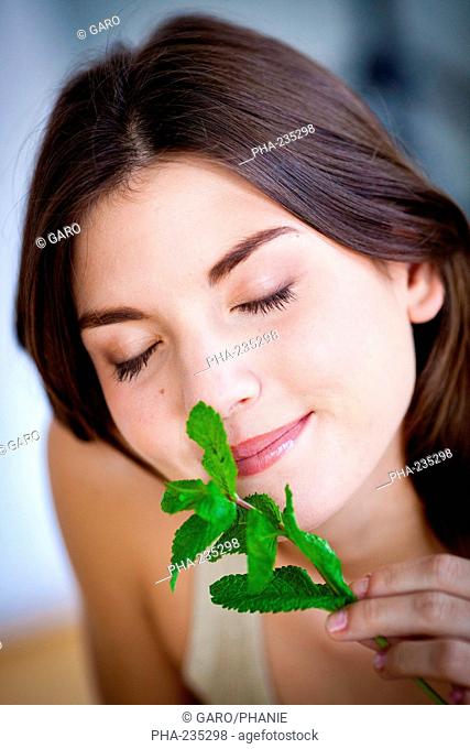 Woman smelling mint leaves Mentha sp