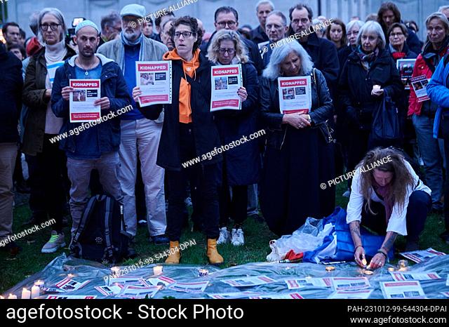12 October 2023, Berlin: People hold sheets of paper with missing persons reports of people who fell victim to Hamas attack in Israel