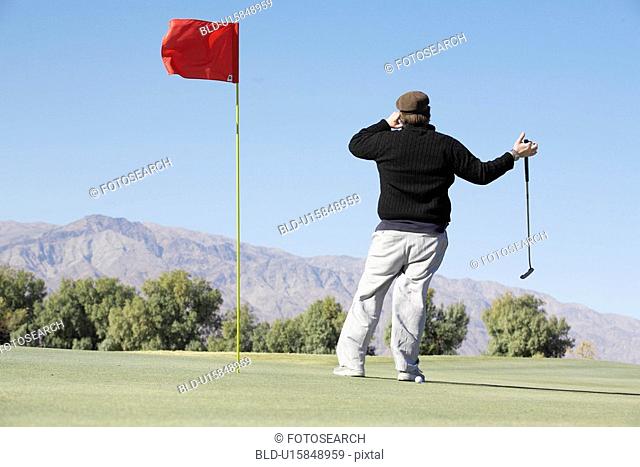 Man on cell phone at golf course