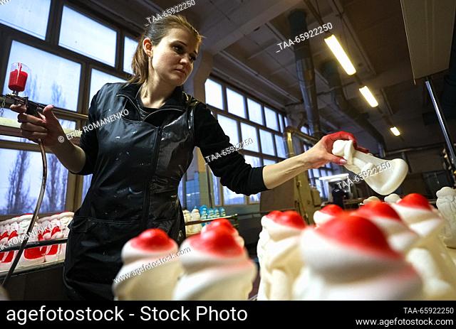 RUSSIA, VORONEZH - DECEMBER 19, 2023: An employee spray paints a Christmas ornament at the Igrushki toy factory. The enterprise is engaged in production of PVC...