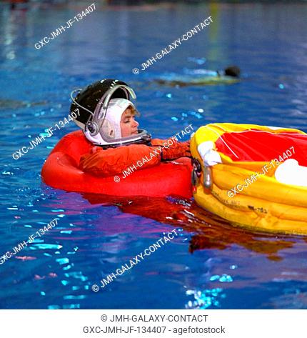 Astronaut Julie Payette prepares to go from dependence on a pair of Mae Wests to a life raft she has just deployed during emergency bailout training