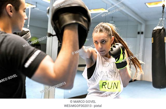Young woman in gym doing boxing training