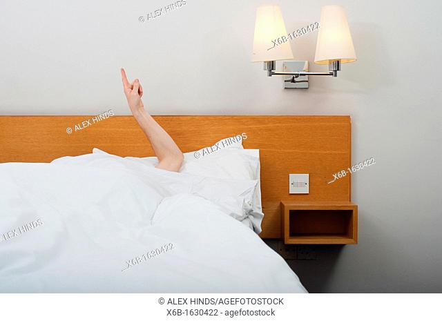 Arm pointing up from under bed covers