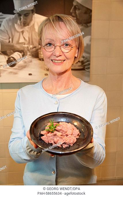 Dog food manufacturer Helga Frambach poses with a feeding dish and cans of 'Hardys Traum' (lit. Hardy's dream) dog food during a media event in Hamburg, Germany