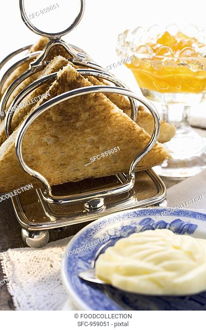 Toast in toast rack, butter, orange marmalade