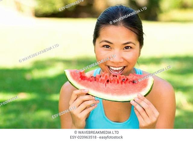 Portrait of a woman eating watermelon in park