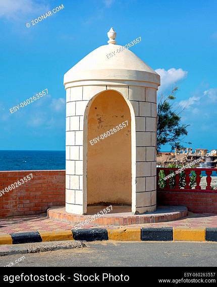 Old guard booth of white bricks with Mediterranean Sea, clear sky, and tree in the background located at Montaza public park, Alexandria, Egypt
