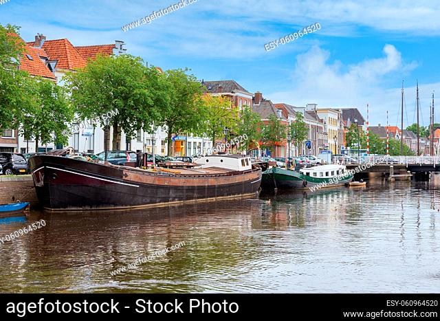 Zwolle, The Netherlands - May 30 2014: Cityscape Dutch medieval city Zwolle with canal and old moored cargo ships