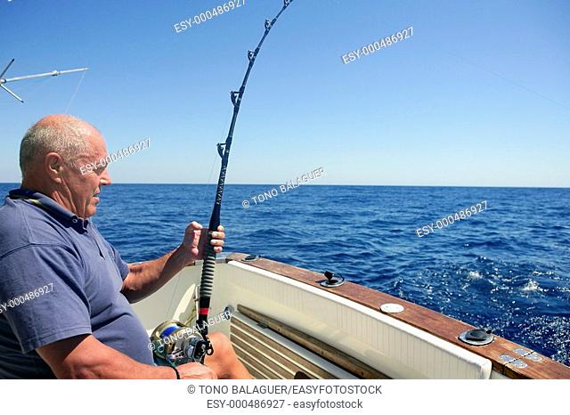 Angler elderly big game sport fishing boat blue summer sea sky