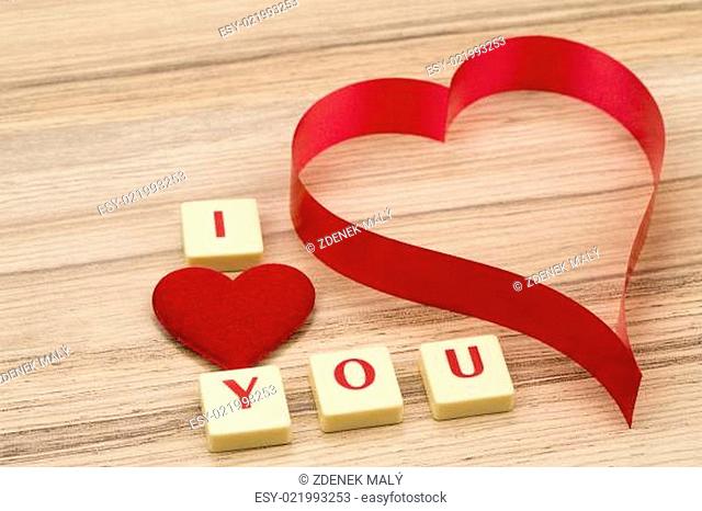 valentine's paper hearts on a wooden background and tex i love you