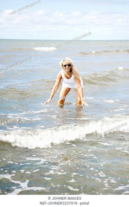 Blond woman playing in sea