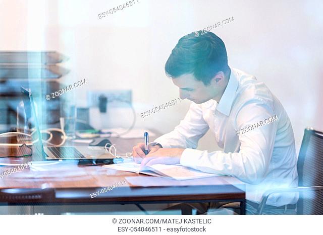 Businessman working with documents in the office. Trough the window glass view