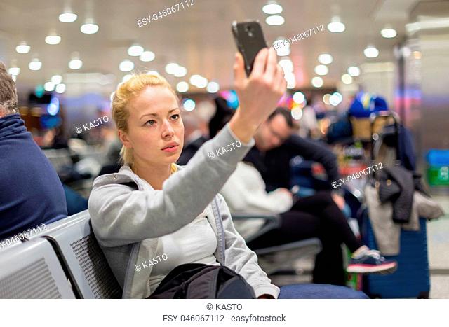 Female traveler taking selfie on airport